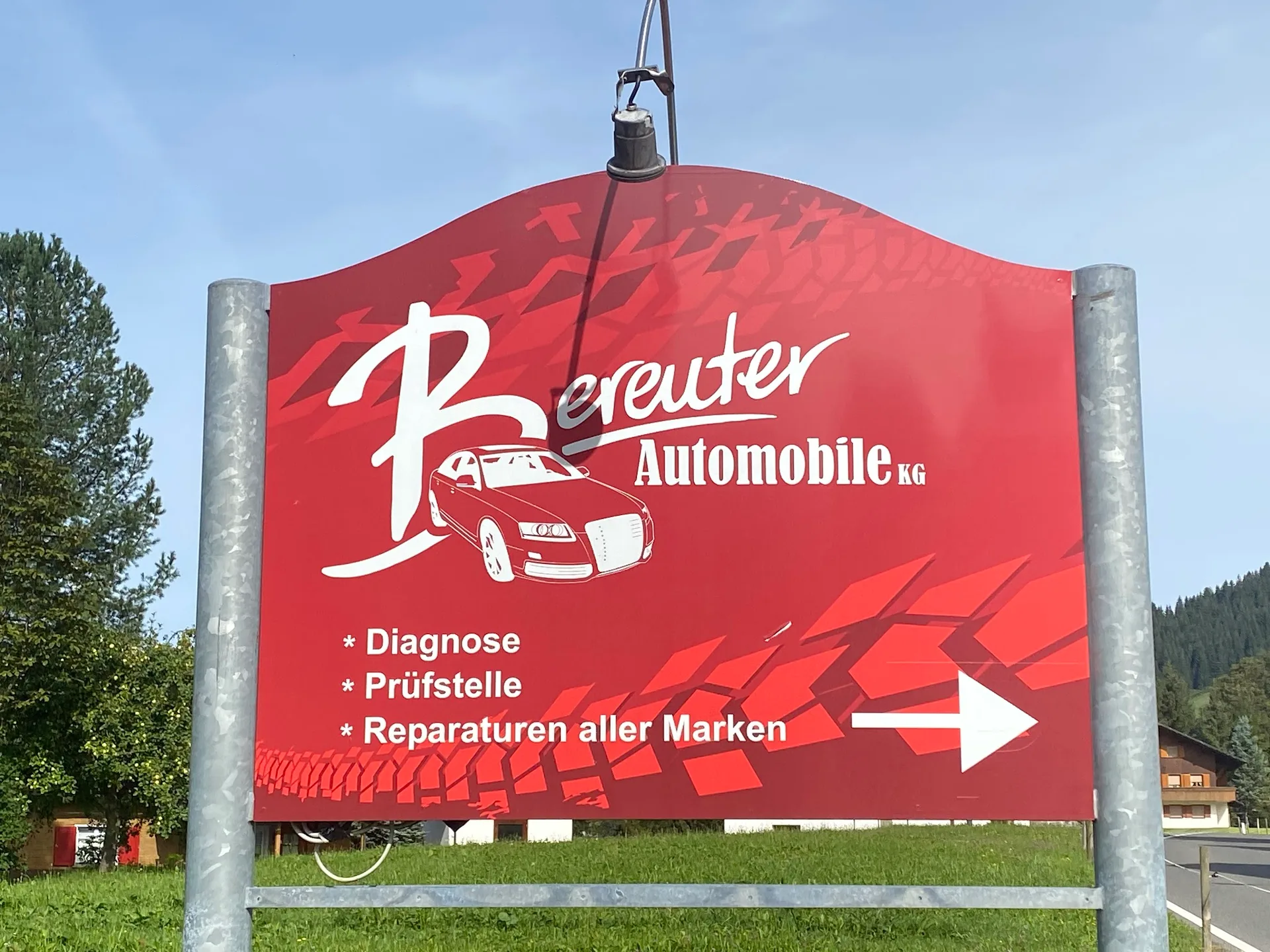 Rotes Straßenschild von Bereuter Automobile mit den Hinweisen Diagnose, Prüfstelle und Reparaturen aller Marken