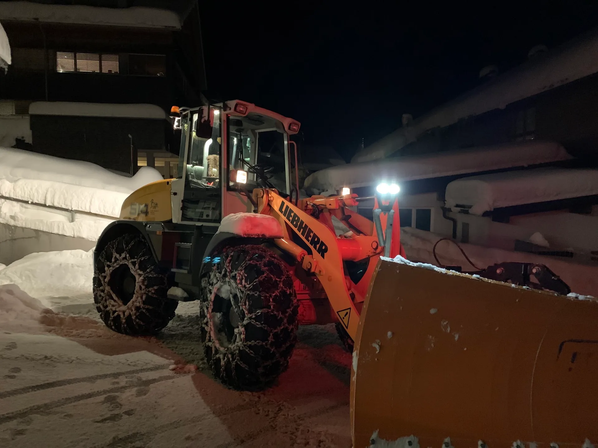 Radlader mit Schneeschild bei Nacht im Tiefschnee beim Winterdienst