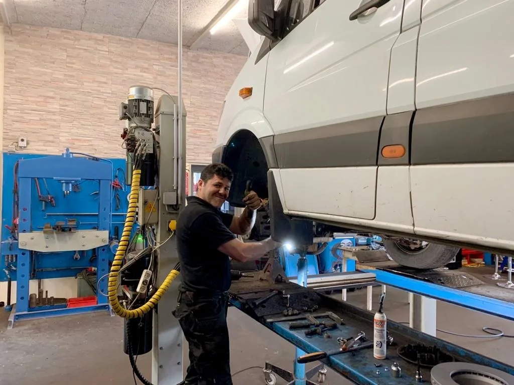 Ibrahim Ergin arbeitet an einem Transporter, der auf der Hebebühne steht